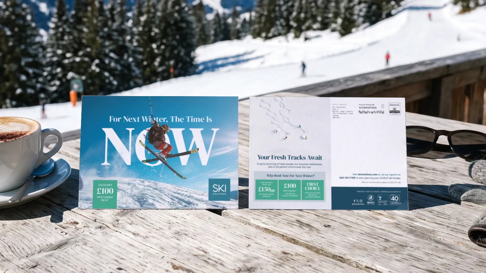 The Ski Solutions early booking mailer, front and back, standing on a sunny mountain terrace table with a cappuccino, in a portfolio visualisation.